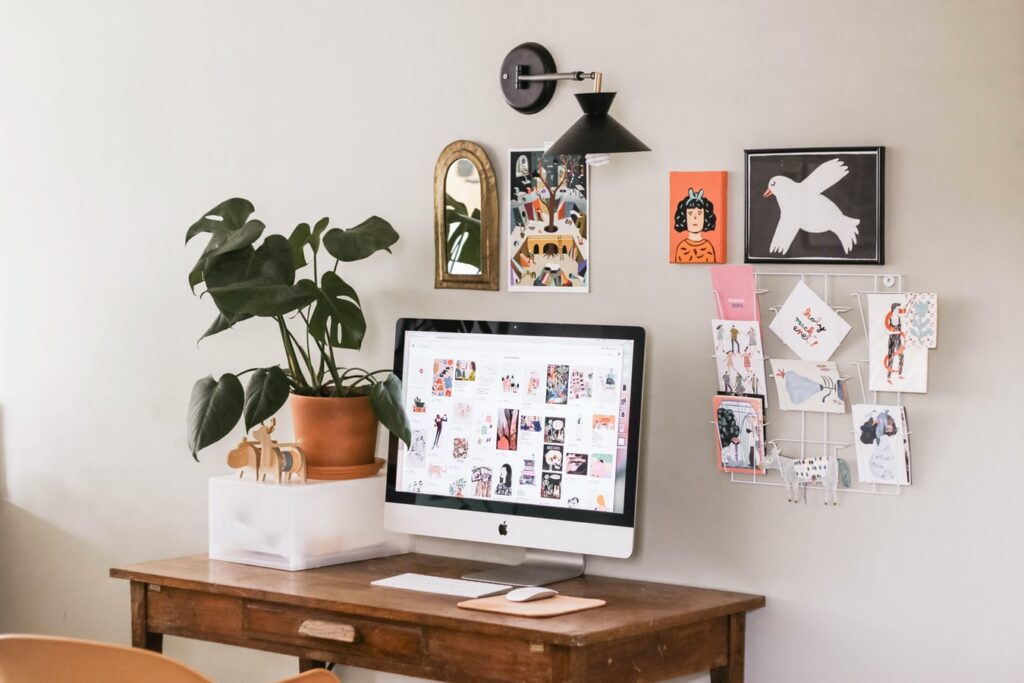 Picture of a wooden desk with a house plant and soft pictures